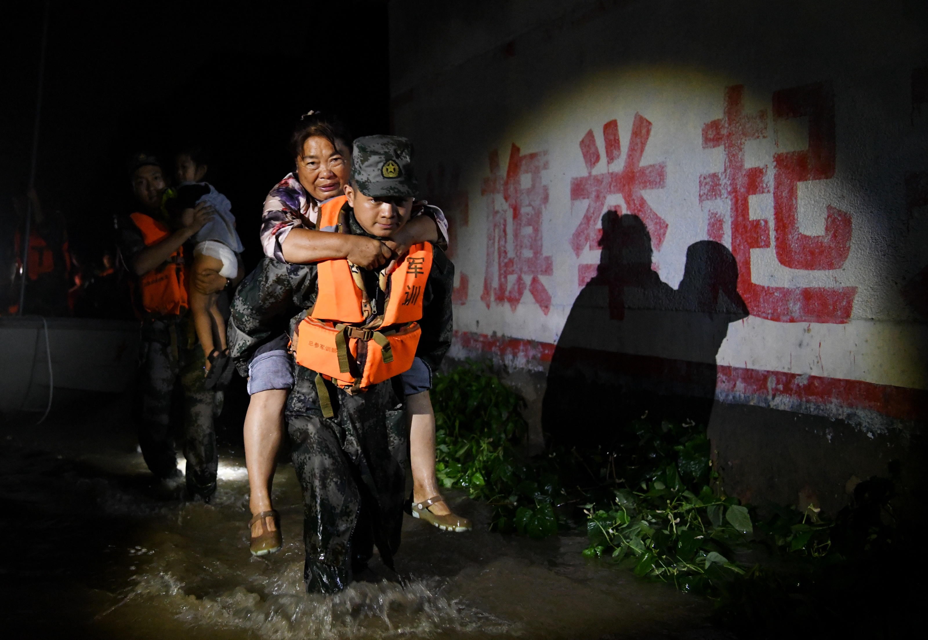 2021 年 7 月，官兵們轉(zhuǎn)移被洪水圍困的群眾。 本報(bào)記者 聶冬晗 本報(bào)通訊員 季鵬.jpeg